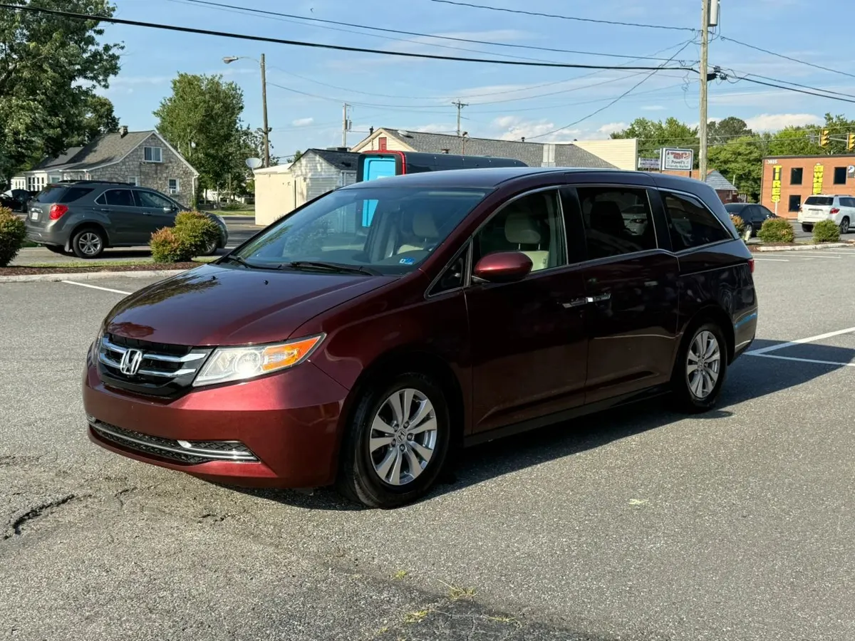A dark red Honda Odyssey minivan parked on the Mix Cars lot on a sunny day