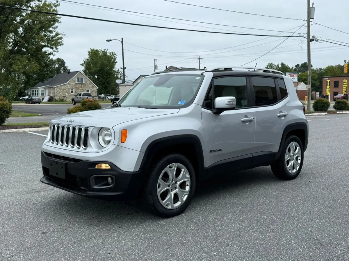 A silver Jeep Renegade Limited small SUV parked on a paved lot, seen from the front driver's side