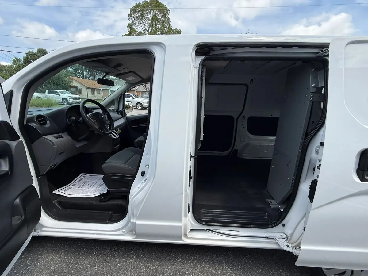 A Nissan NV200 with its sliding side door and front door open, showing the cargo area and the cab